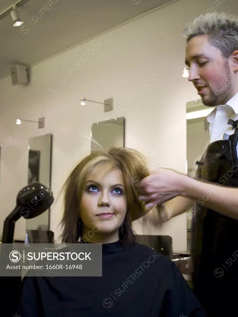 Young woman at hair salon with hairdresser