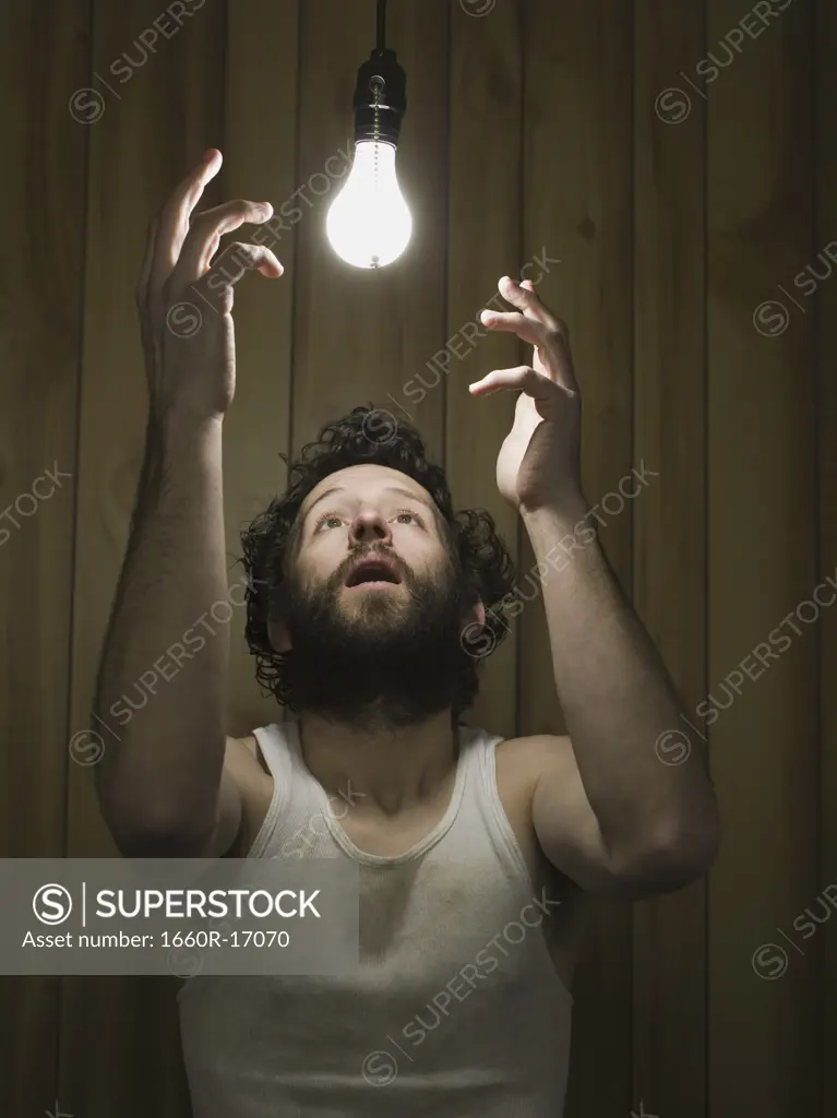 Man reaching up to light bulb