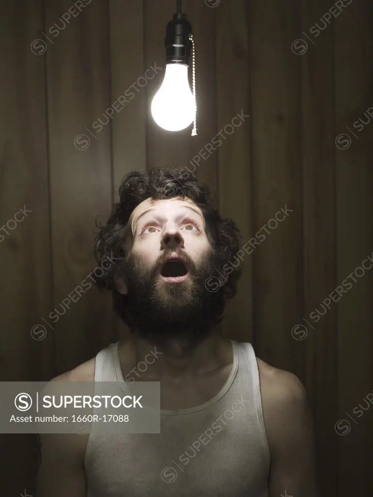 Man looking up at light bulb