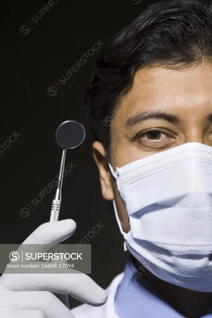 Close-up of dentist with mask and mirror