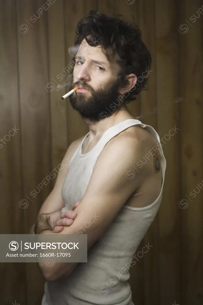 Man standing with cigarette and crossed arms