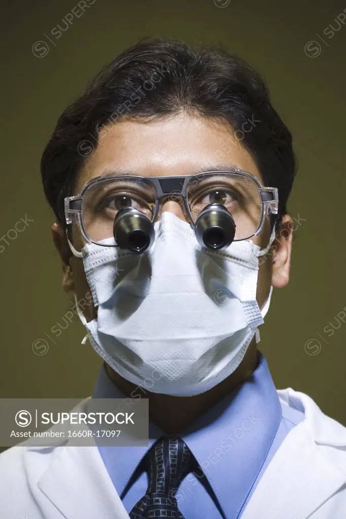 Man in surgical mask with microscopic glasses