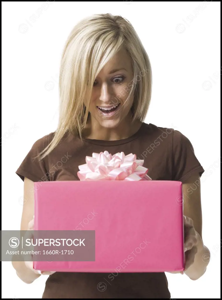 Young woman looking at a gift in her hands