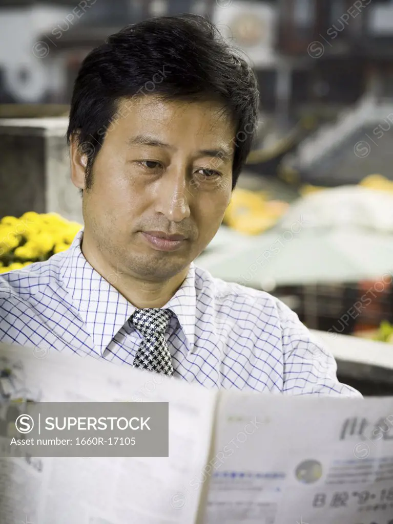 Businessman with newspaper outdoors