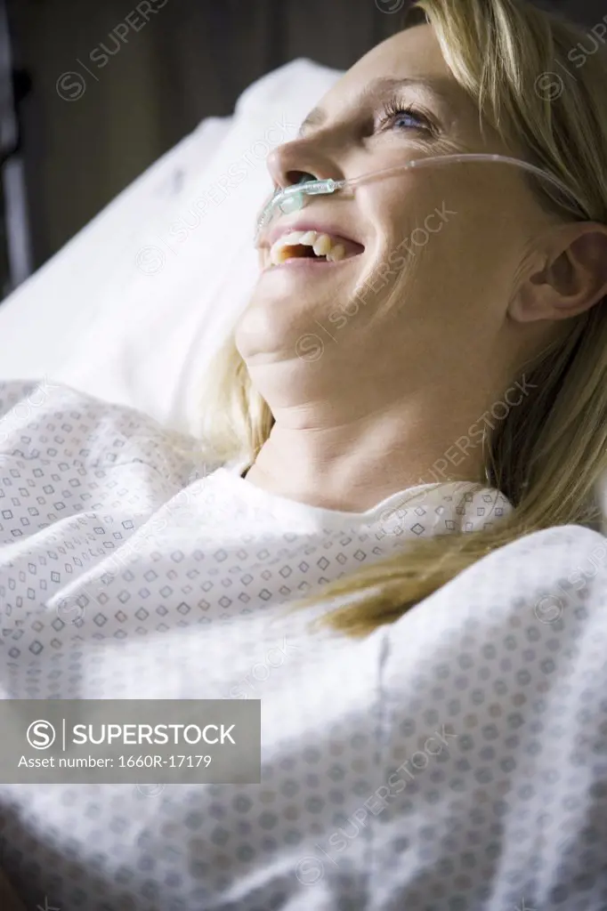 Woman in hospital with respirator smiling
