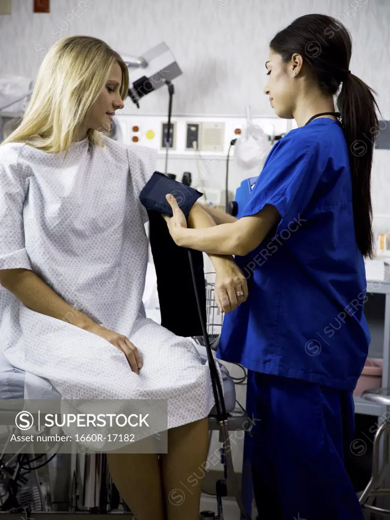 Female patient with blood pressure cuff during examination with nurse