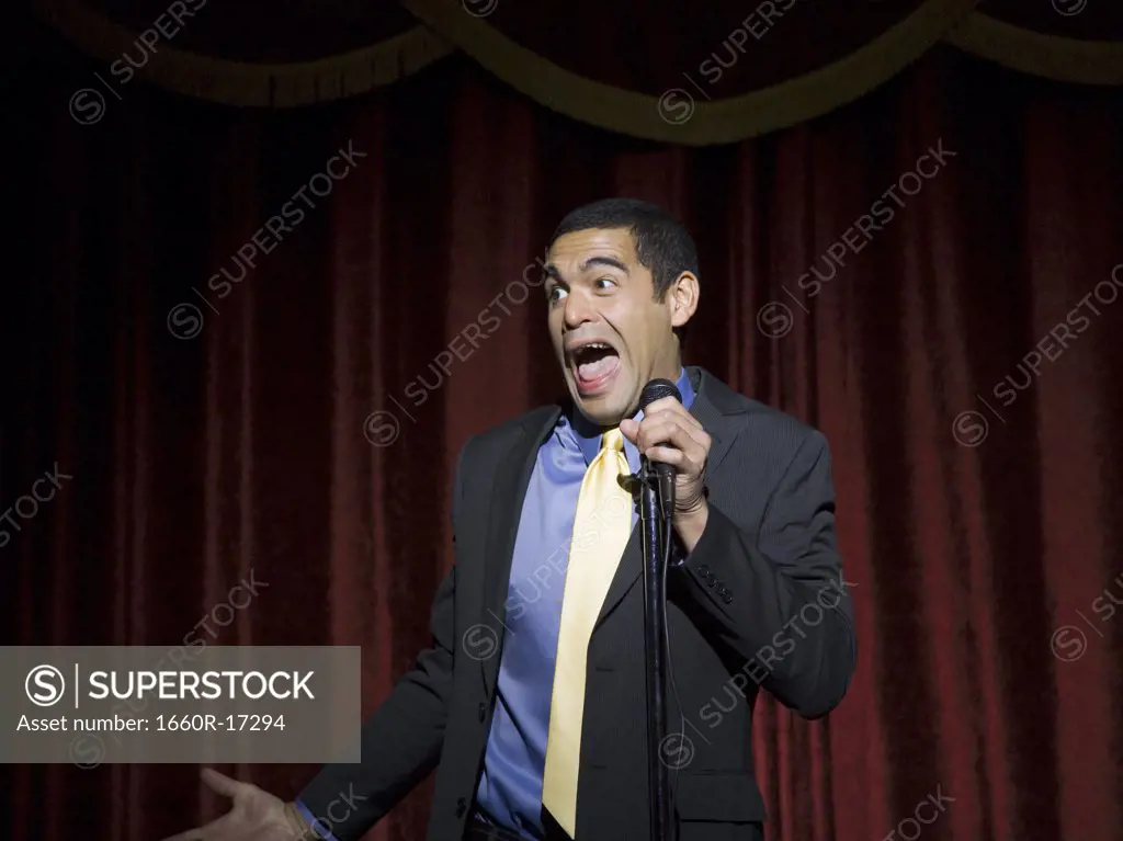 Man in suit with microphone making funny faces