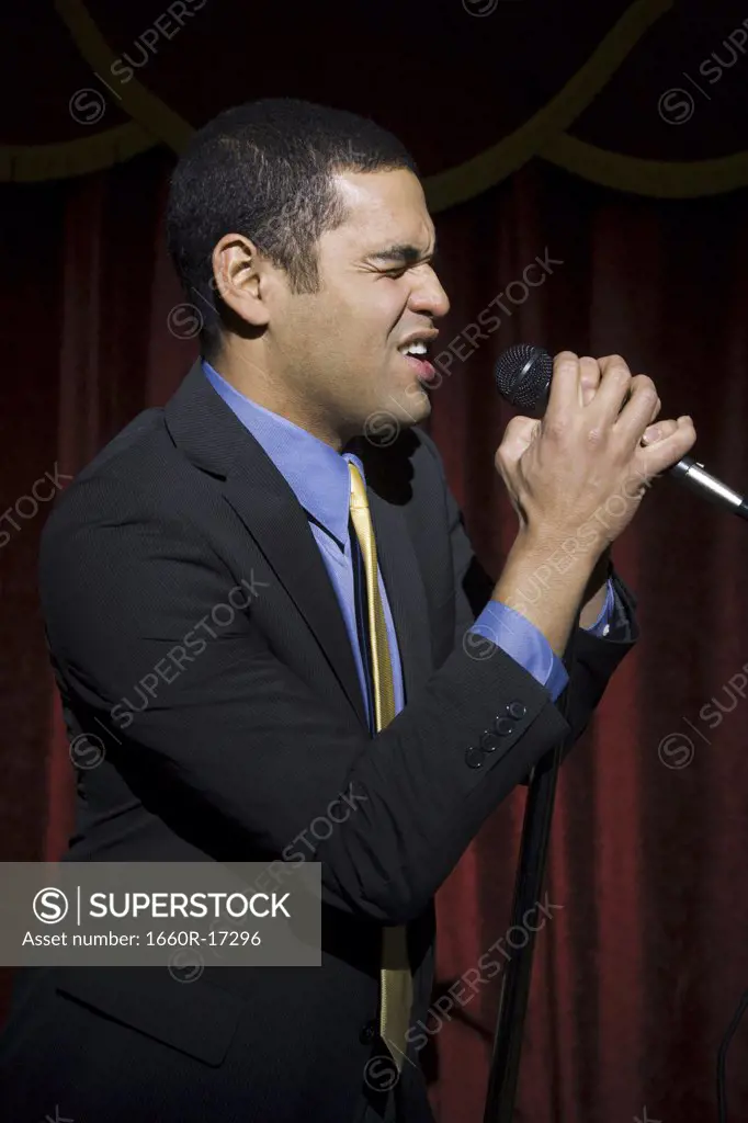 Man in suit with microphone making funny faces