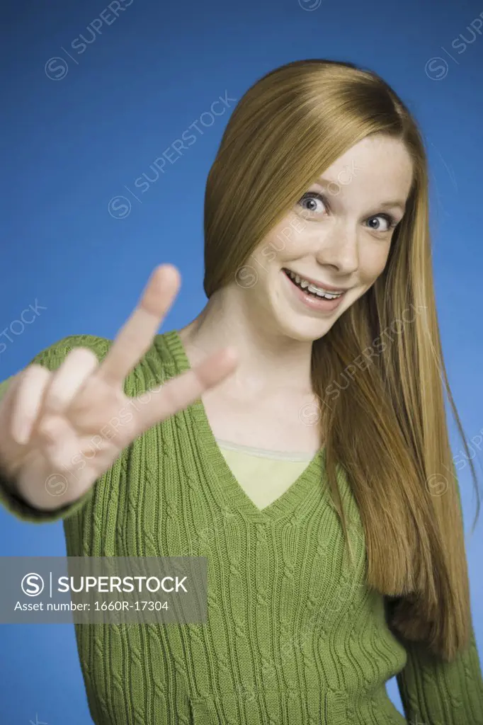 Girl making peace sign smiling