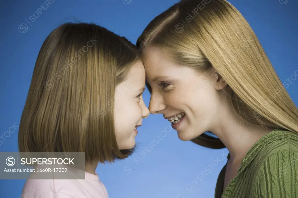 Two girls face to face smiling