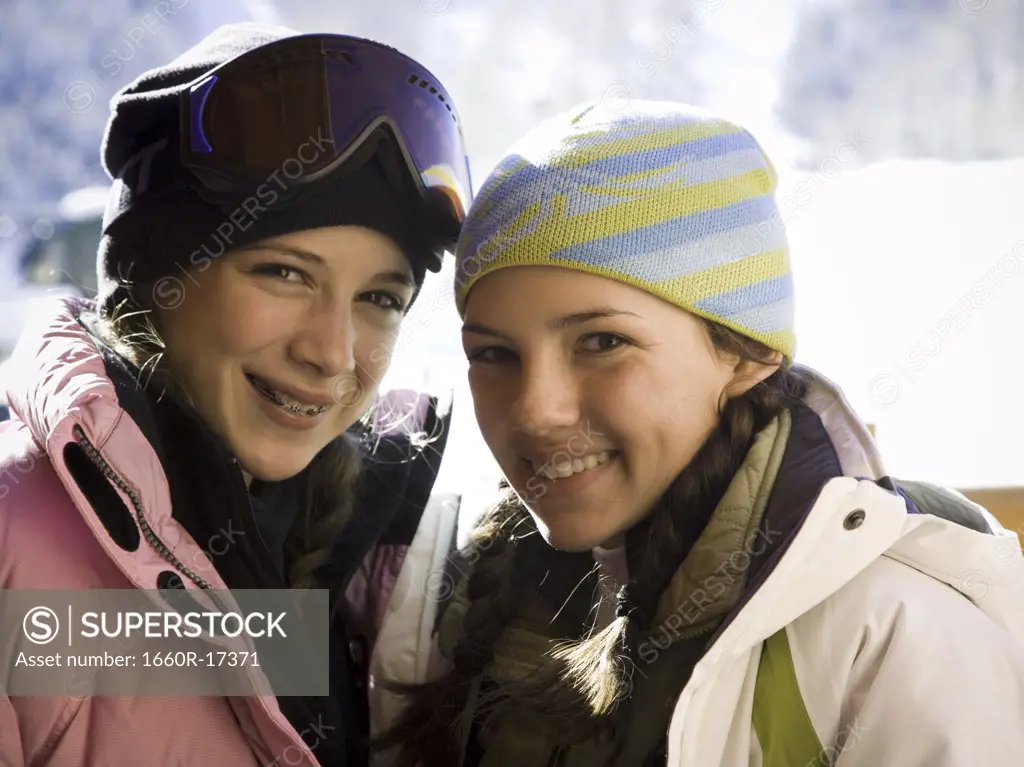 Two teenage girls outdoors in winter with toques