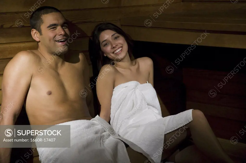 Man and woman in sauna smiling