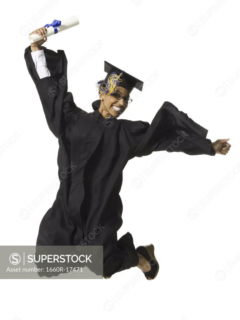 Woman in graduation gown and Blank Sign with diploma jumping