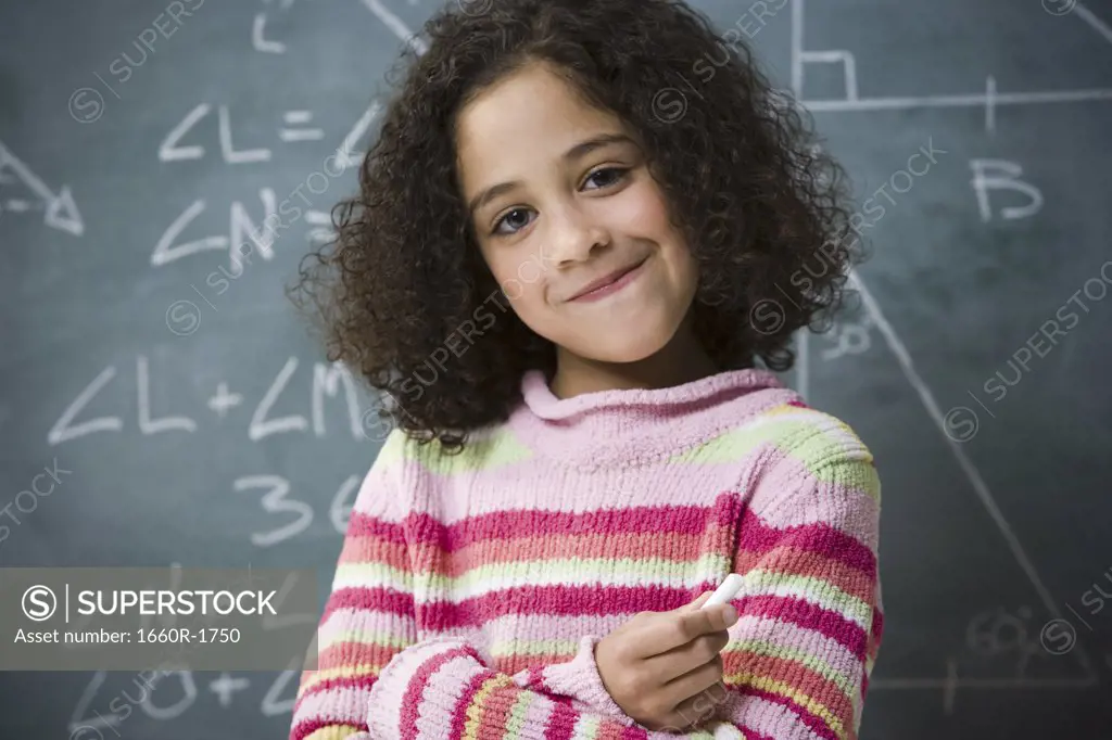 Portrait of a girl standing in front of a blackboard