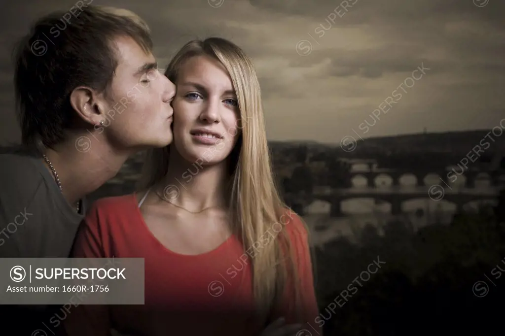 Profile of a young man kissing a teenage girl's cheek