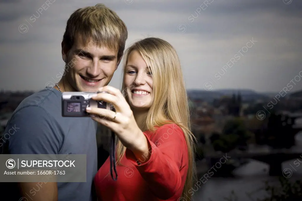 Close-up of a young man and a young woman photographing themselves