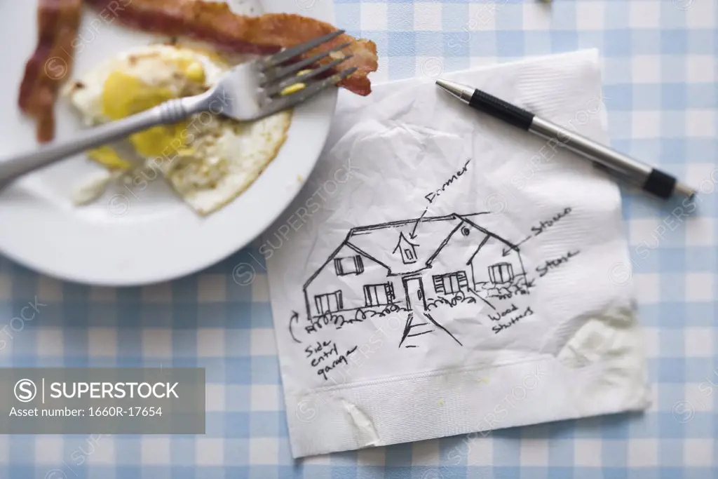 Bacon and eggs with fork and napkin with pen and sketch of house