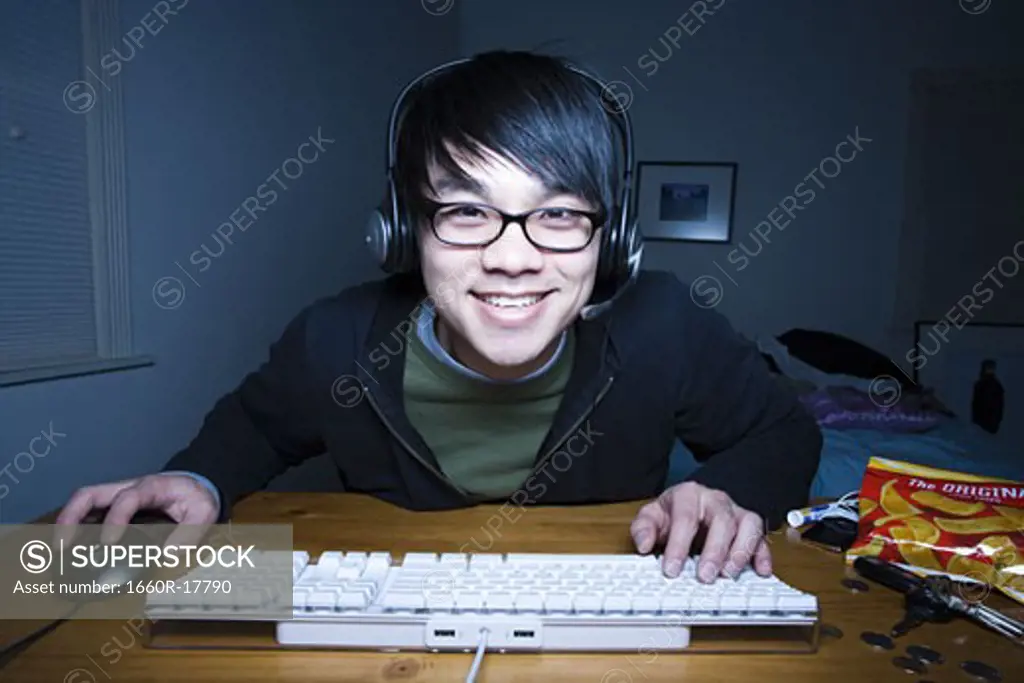 Man at keyboard with headset smiling
