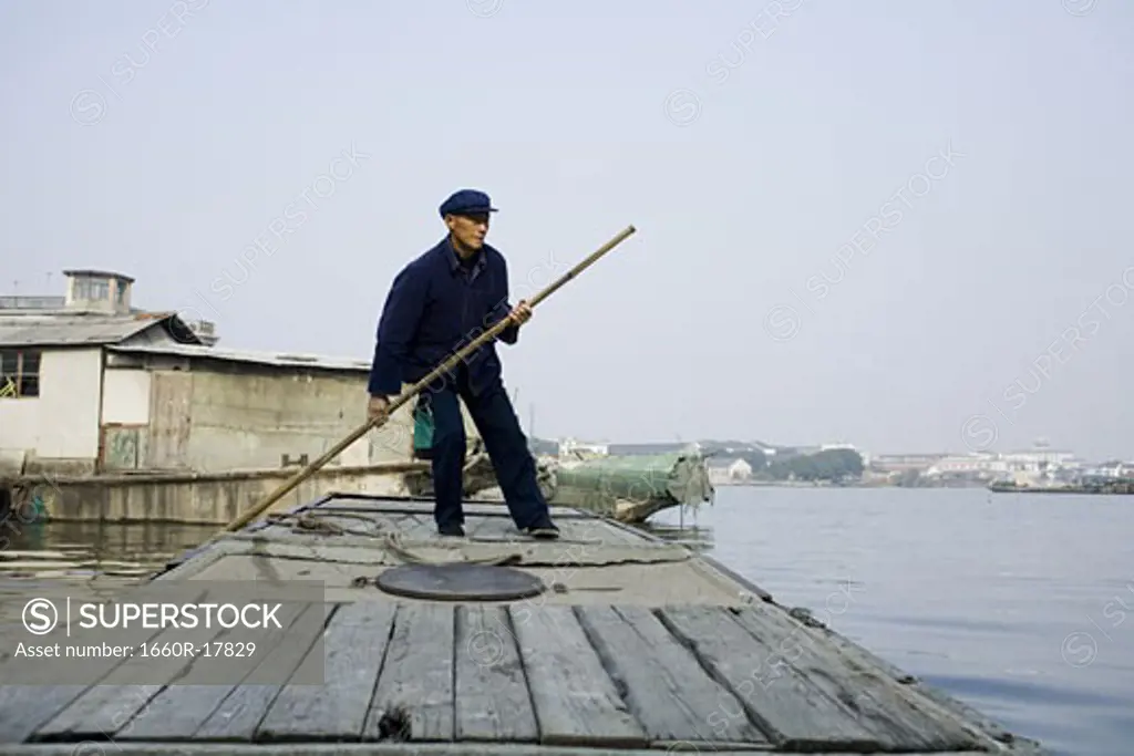 Man with pole standing on dock outdoors