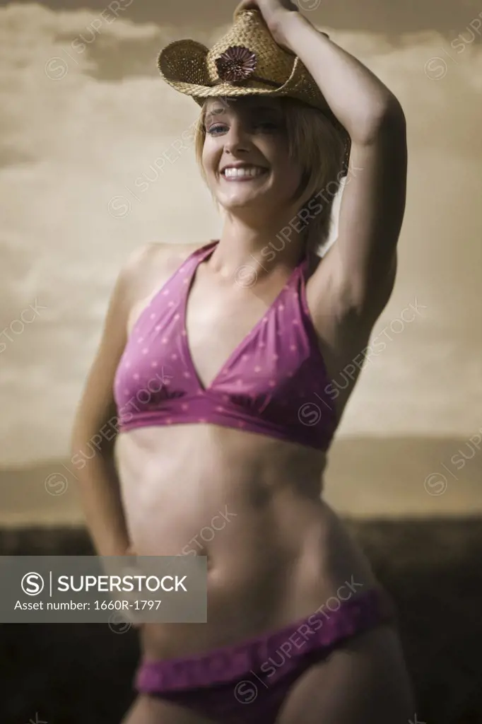 Young woman in a bikini wearing a straw hat