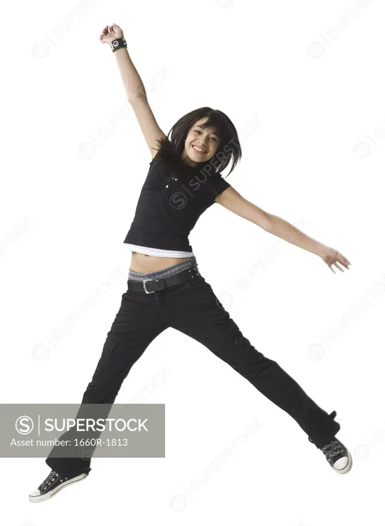 Teenage girl jumping with her arm outstretched