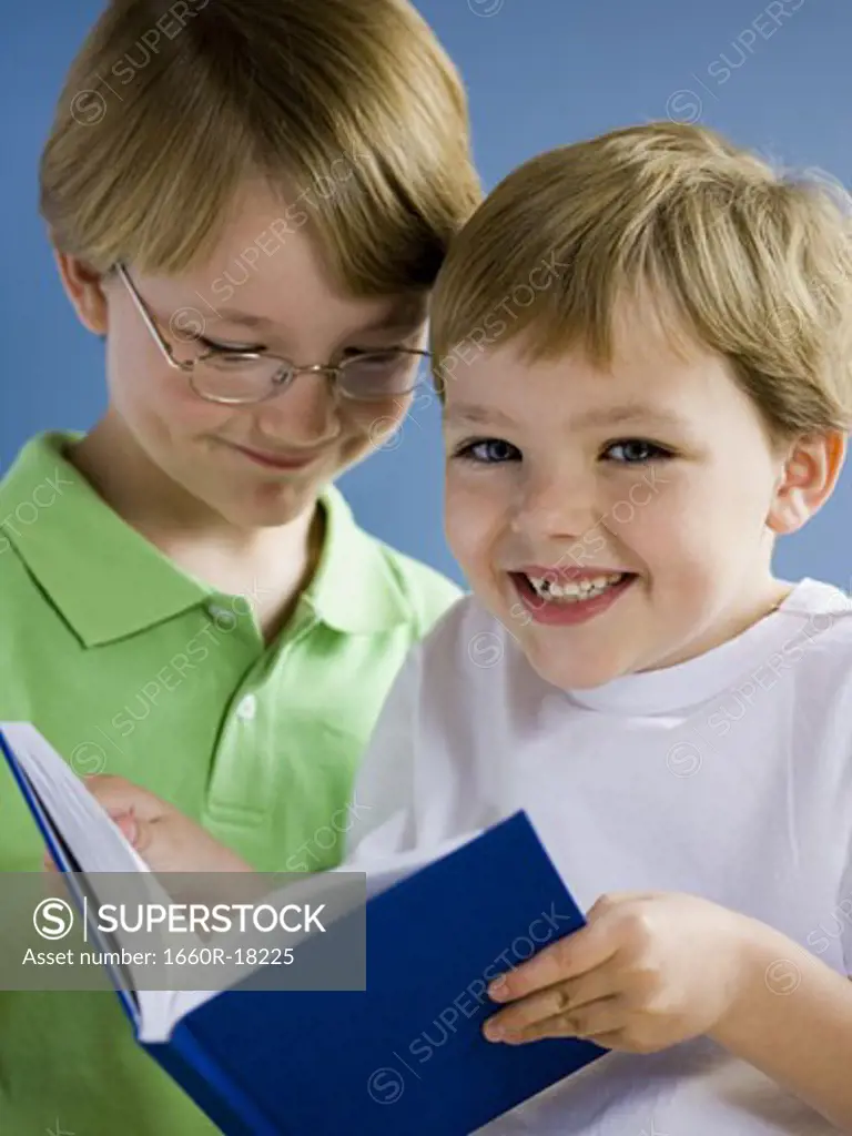 Two boys reading book