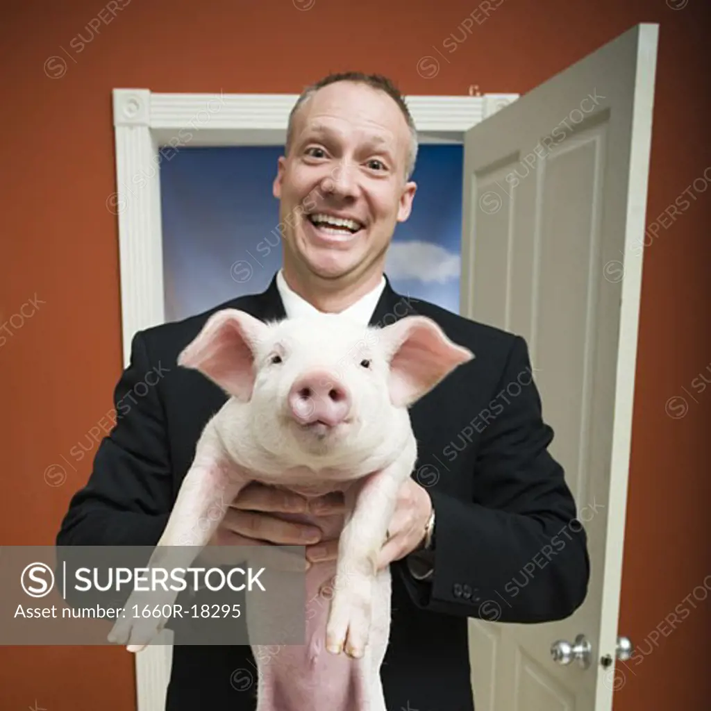 Man at home with piglet smiling