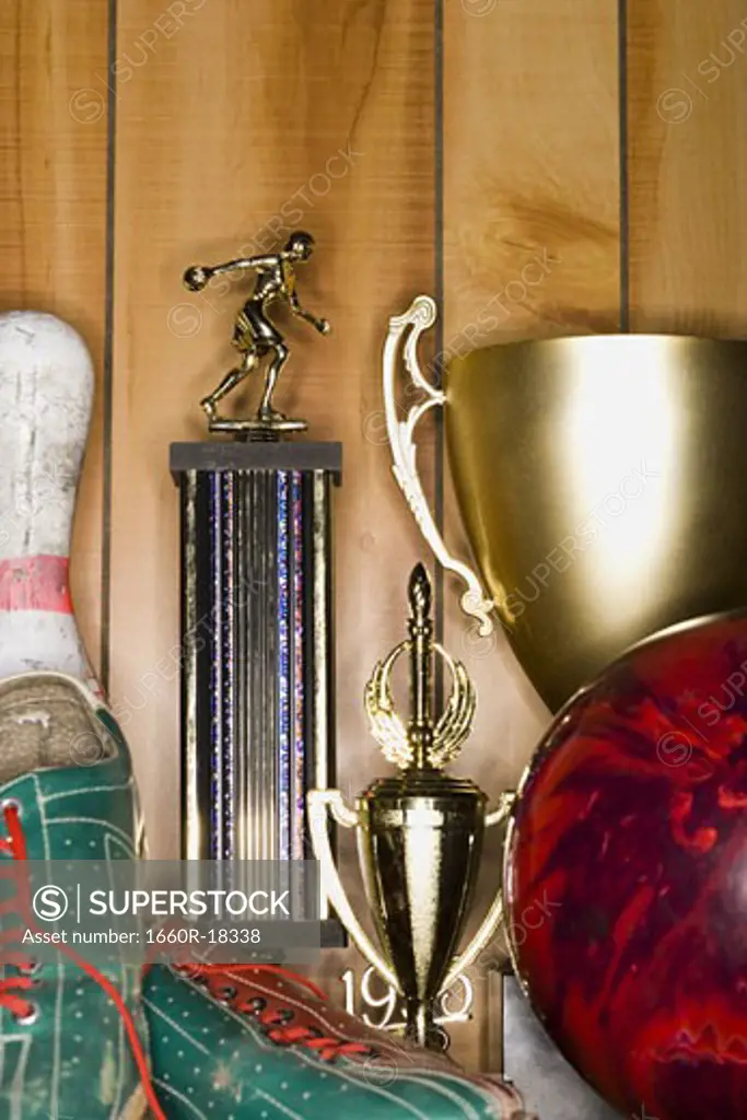 Bowling ball and pin with shoes and trophies