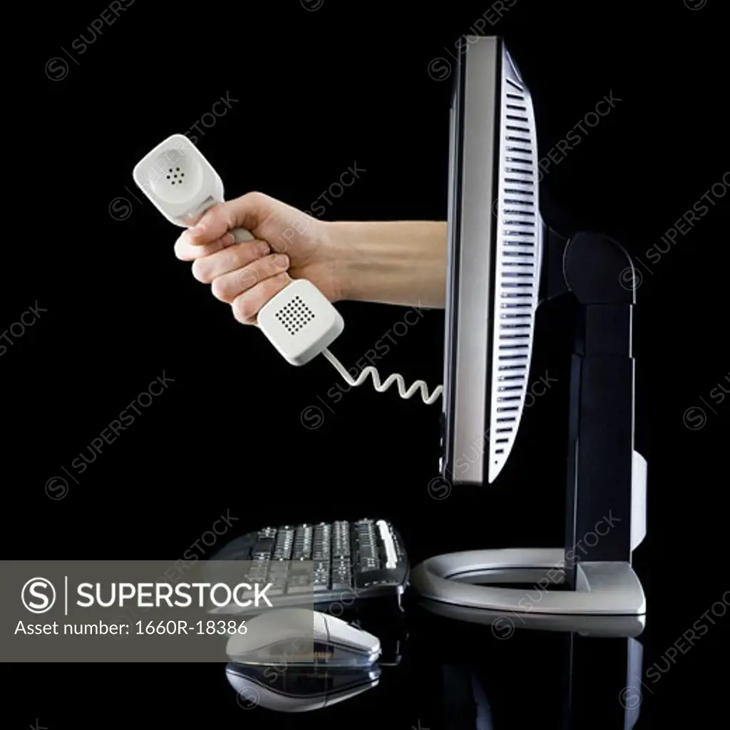 Profile of computer with hand from monitor holding telephone receiver