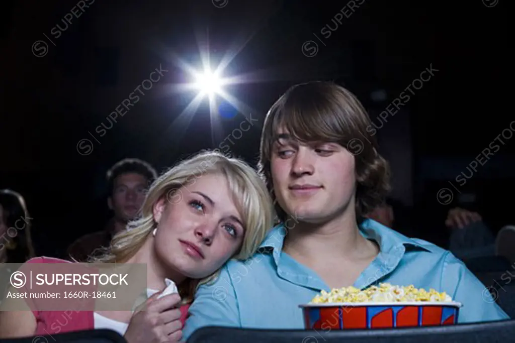 Girl crying at movie theater with boy and popcorn