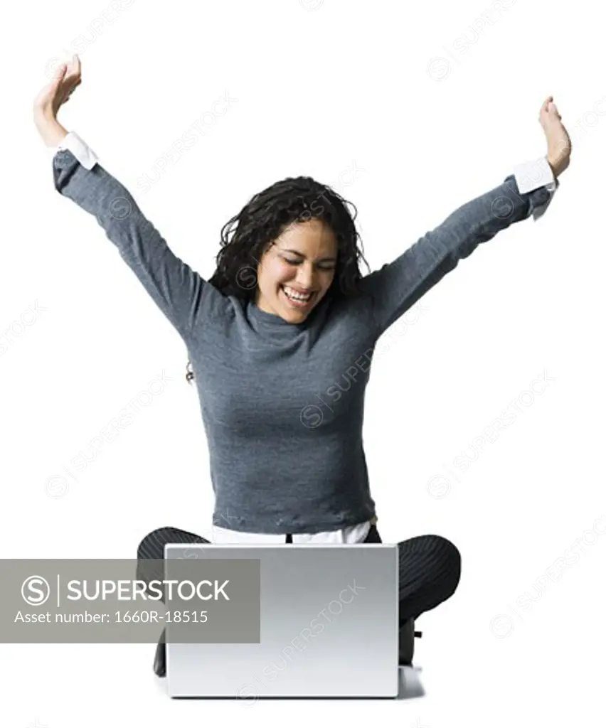 Woman sitting cross legged with laptop stretching