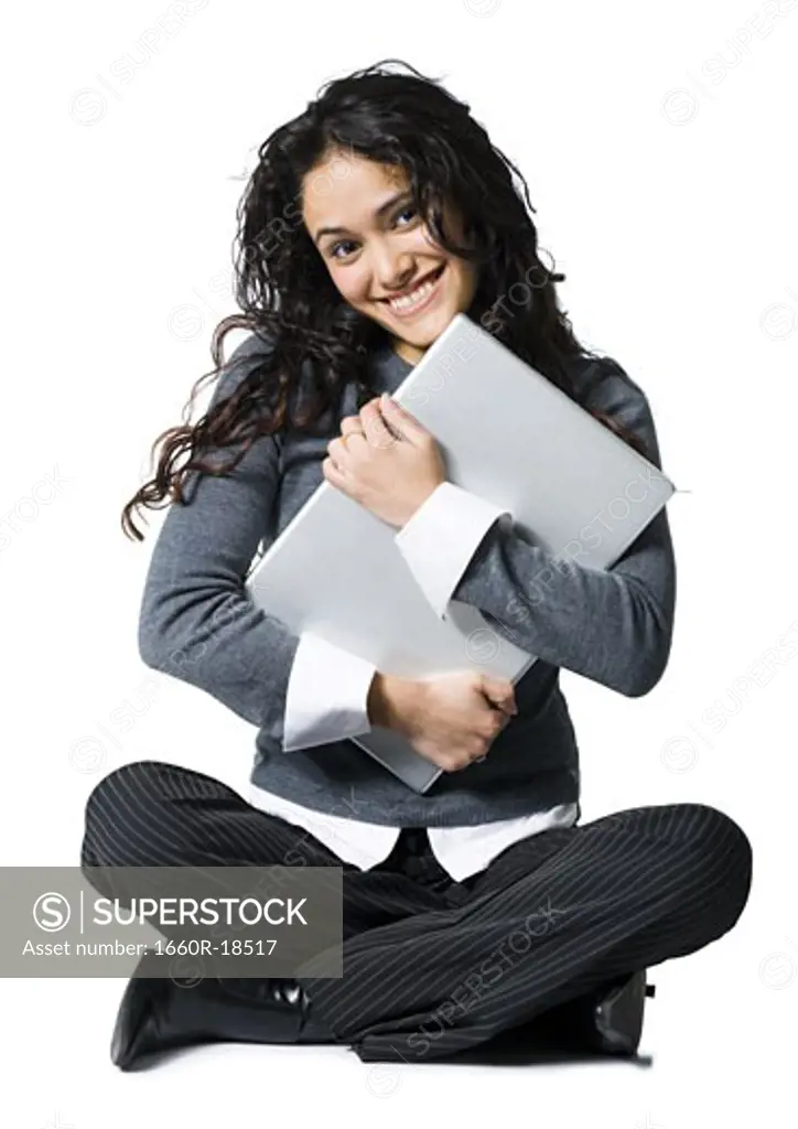 Woman sitting cross legged hugging laptop