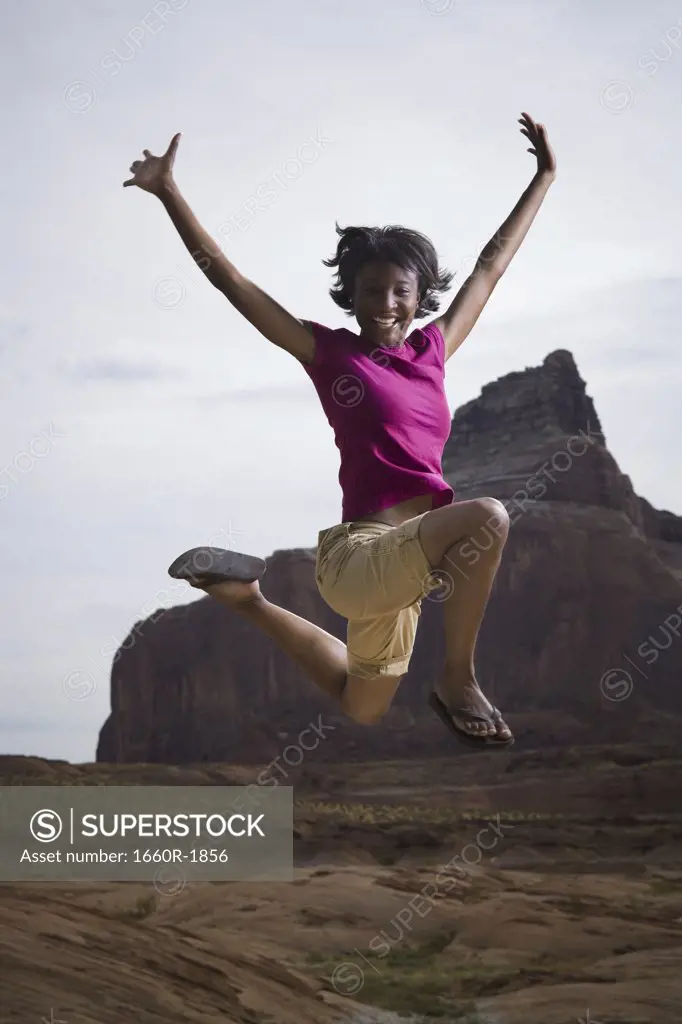 Portrait of a young woman jumping outdoors