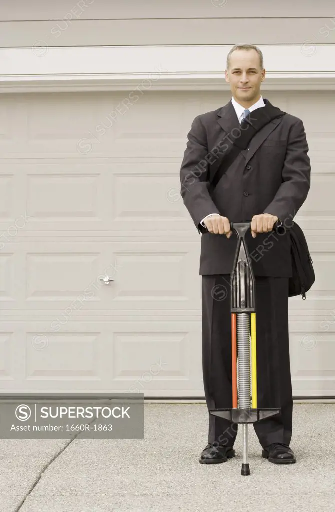 Portrait of a businessman holding a pogo stick