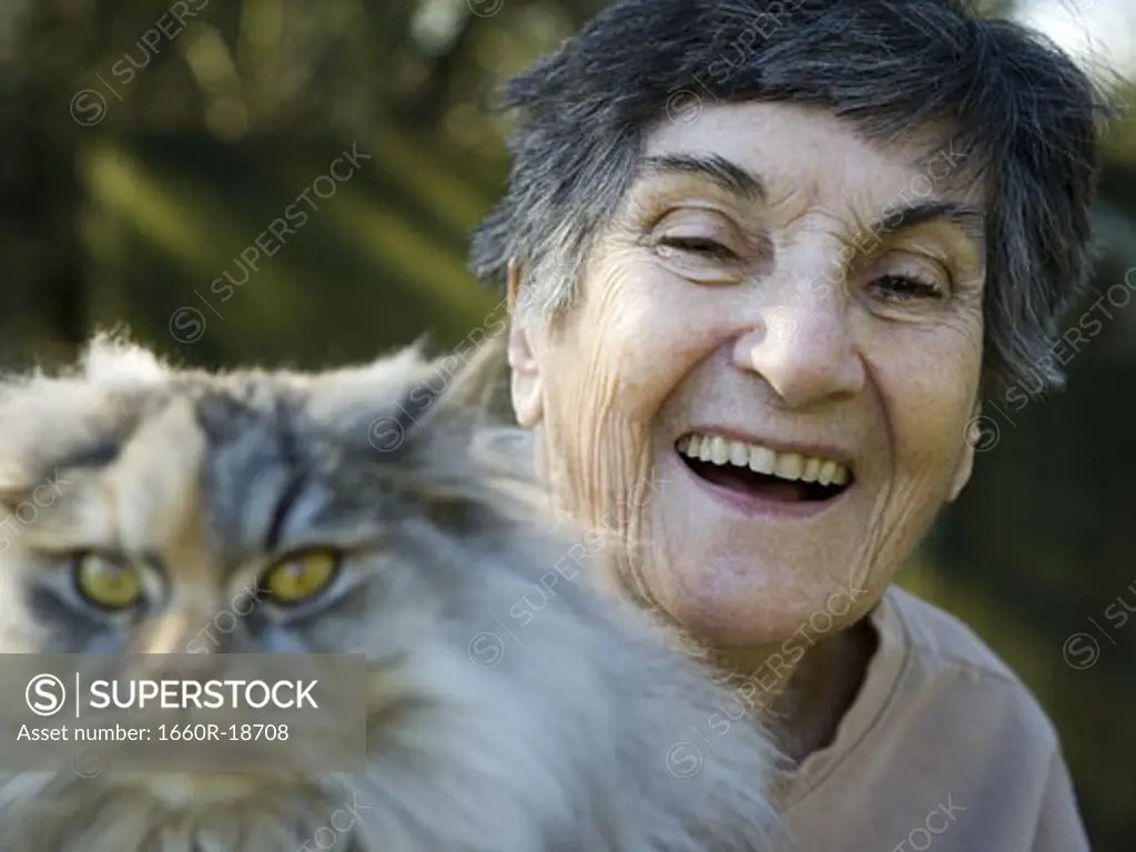 Woman smiling with cat outdoors