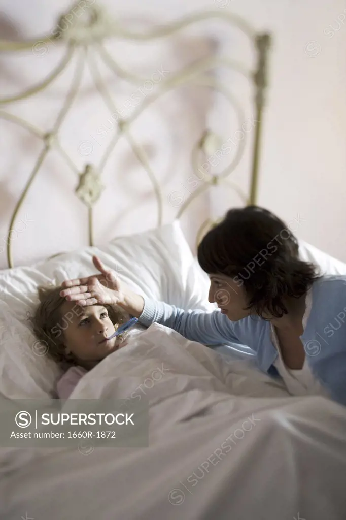 High angle view of a mother checking her daughter's temperature