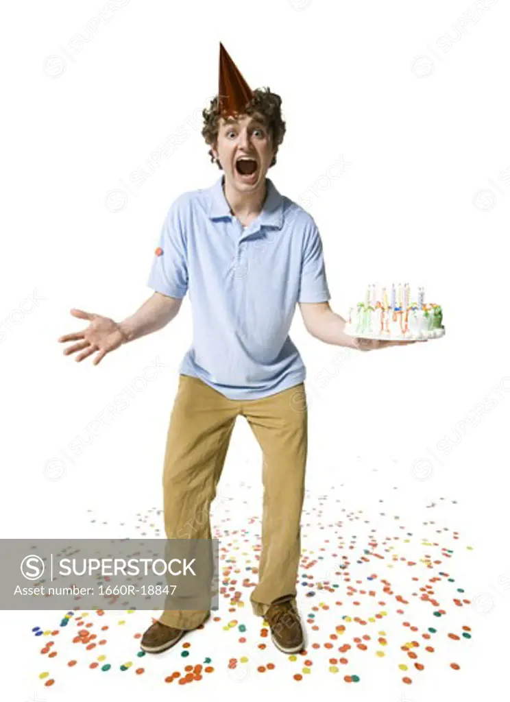 Man with party hat holding birthday cake