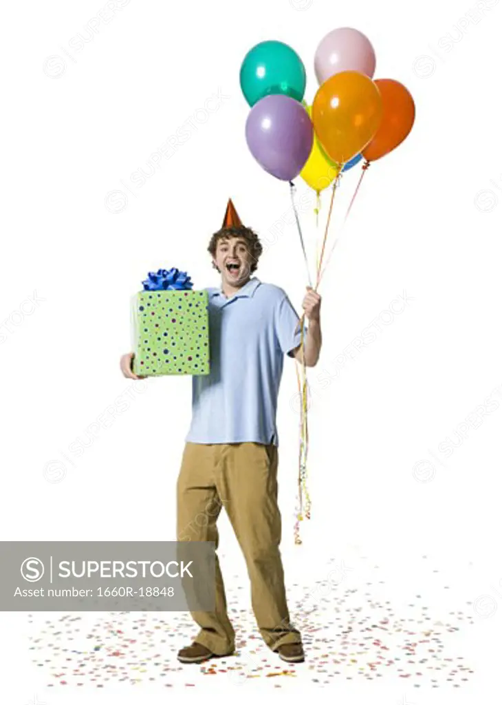 Man with party hat holding balloons and gift box