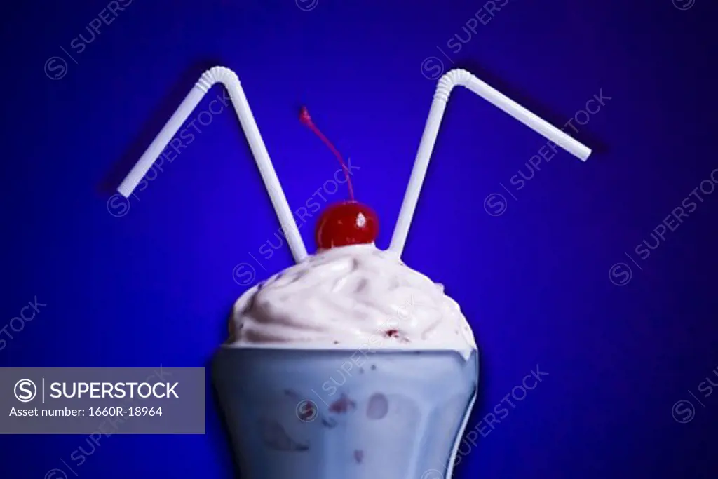 Milkshake with two straws and maraschino cherry