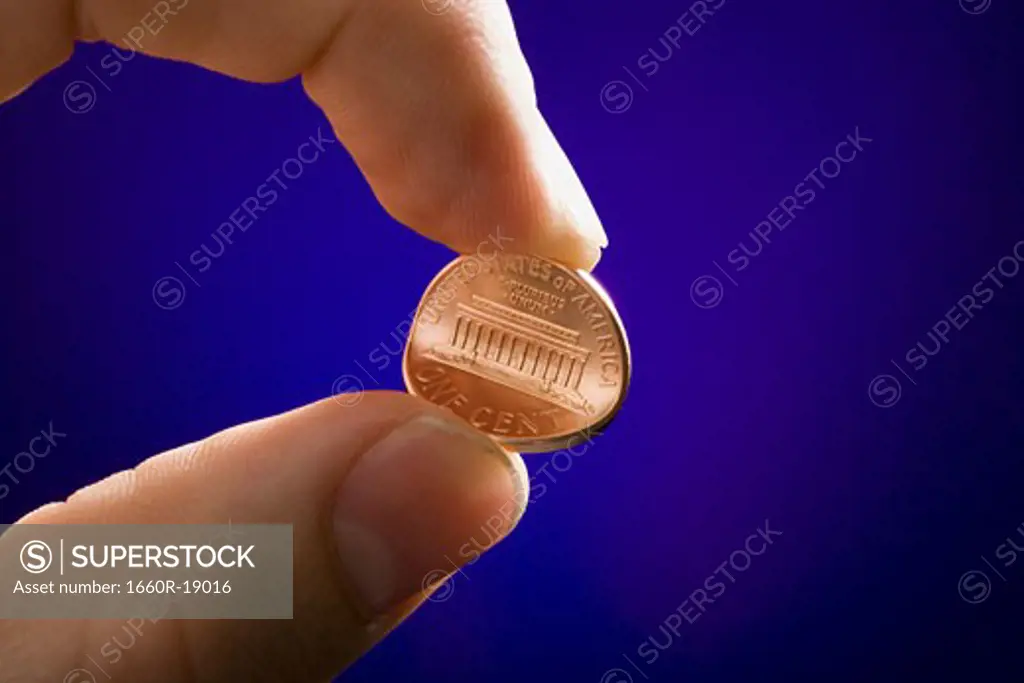 Detailed view of male hand bending penny