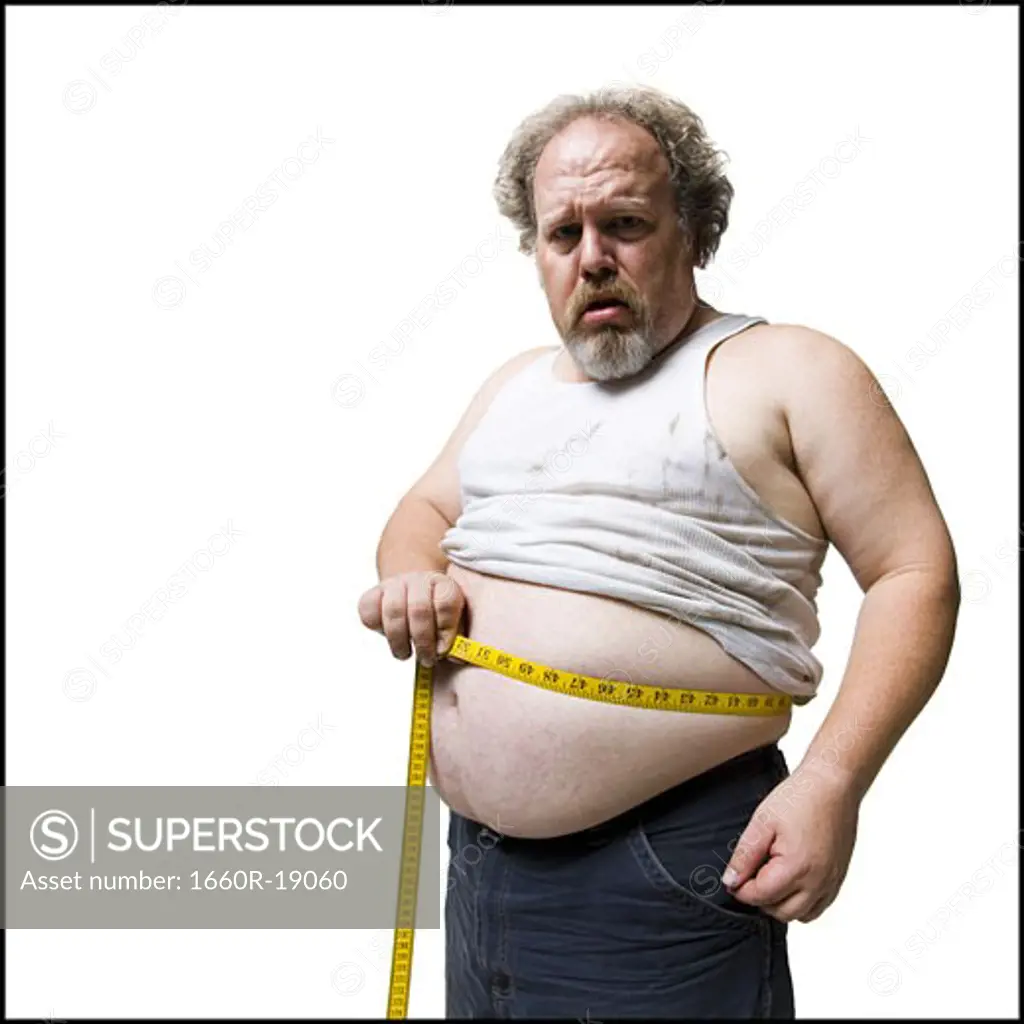 Obese man measuring waist with tape measure