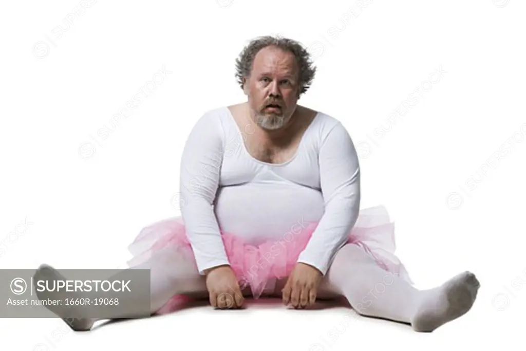 Obese man in tutu sitting on ground