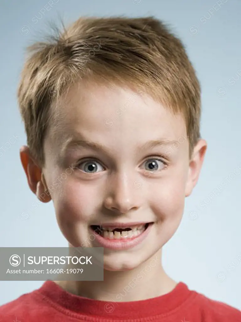 Close-up of boy smiling with missing front teeth