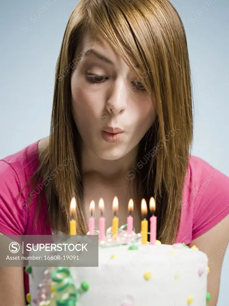 Woman blowing out candles on a birthday cake