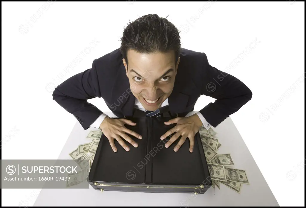 Young businessman with banknotes falling out of briefcase