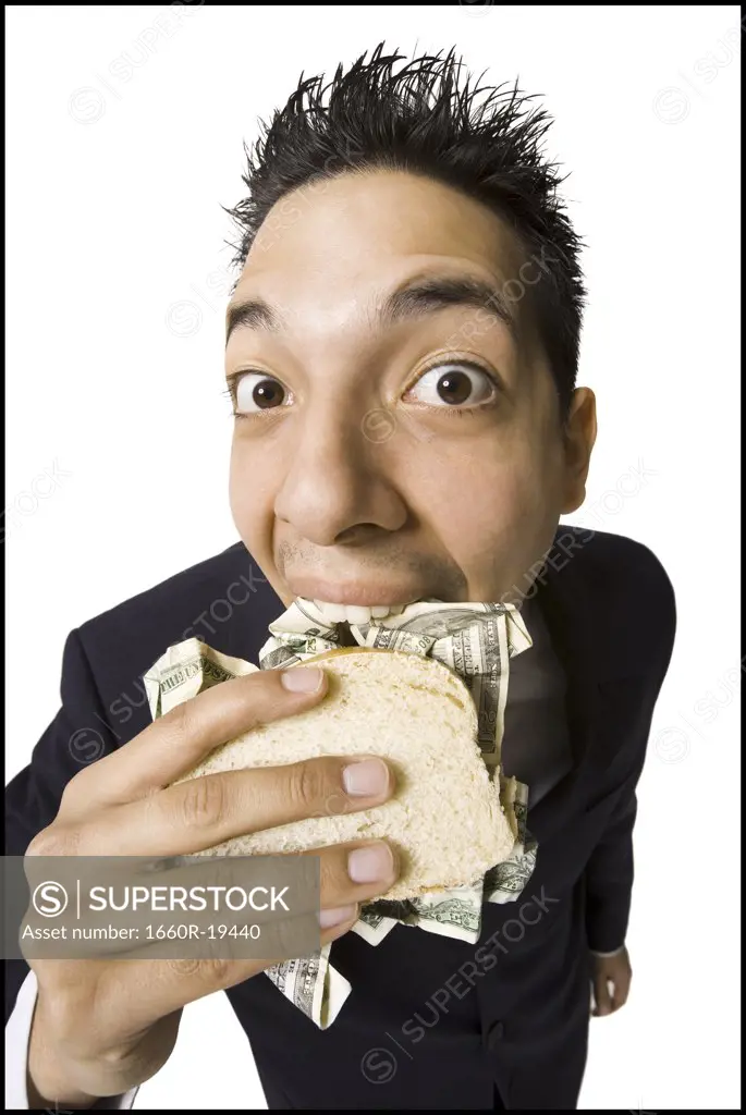 Young businessman eating money sandwich
