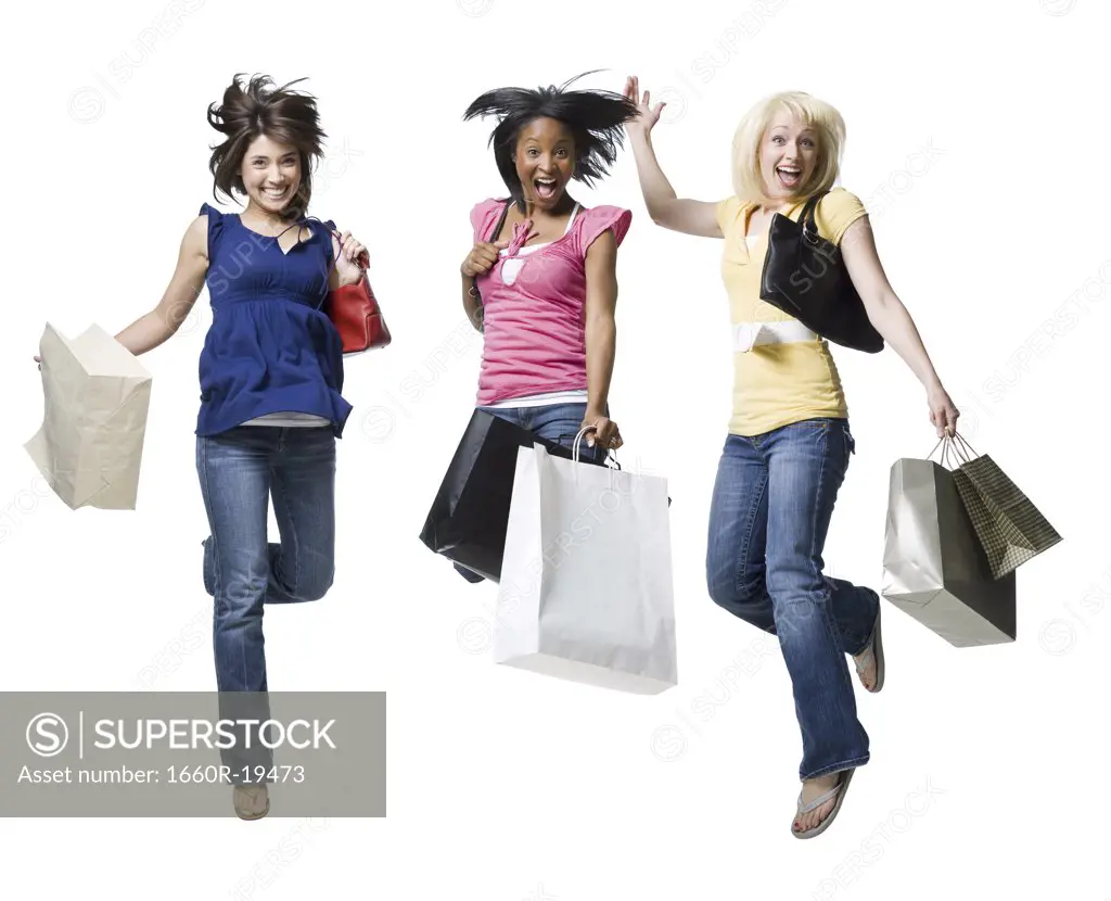 Three women jumping and smiling with shopping bags