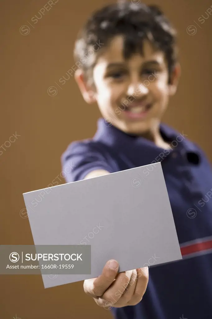 Boy holding blank card smiling