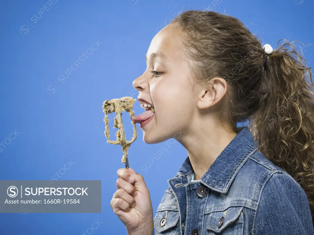 Profile of girl licking batter off beater