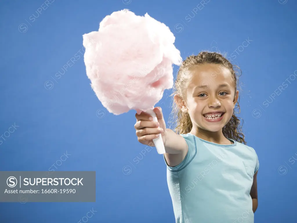 Girl holding cotton candy smiling